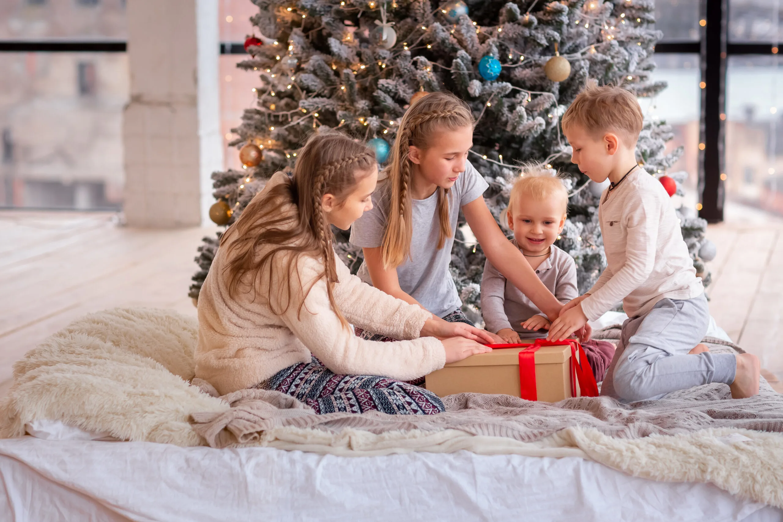 kids opening gifts under a tree