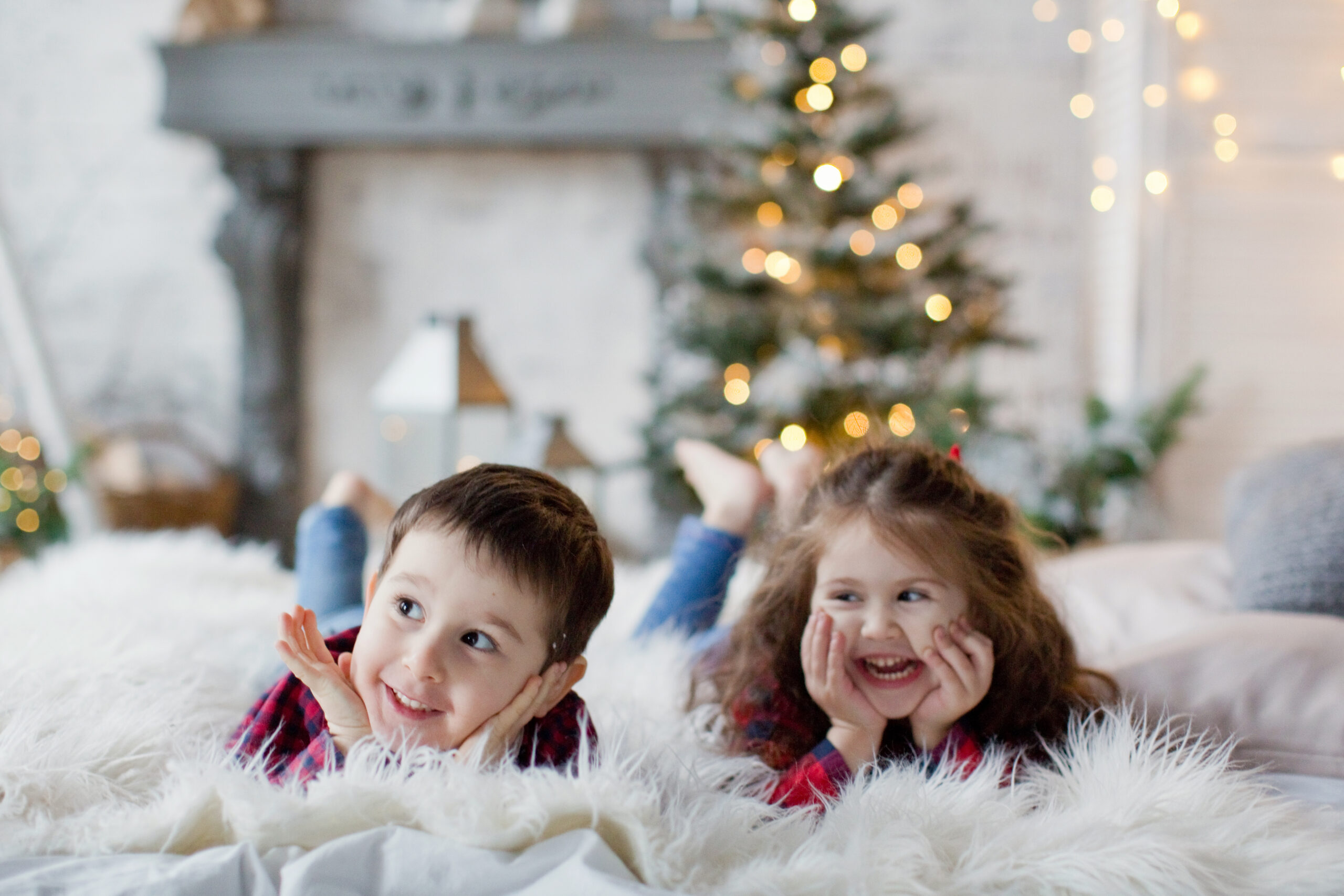 kids with Christmas tree in background. Text overlay on pin reads "minimalist Christmas gifts for kids! Stuff they actually want!